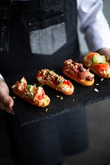 Eclairs with salmon, fresh vegetables and herbs, gourmet snacks.