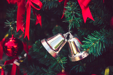 Twin silver bells and red ribbon with red Christmas balls adorn on Christmas tree.  Christmas background. New Year concept.