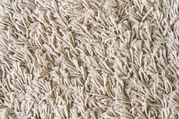 The texture of a soft, fleecy, light-colored floor rug