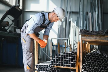 Male factory mechanics or Engineer in safety uniforms are working on metal drilling machines in industrial production lines, steel processing industry, mechanical maintenance.