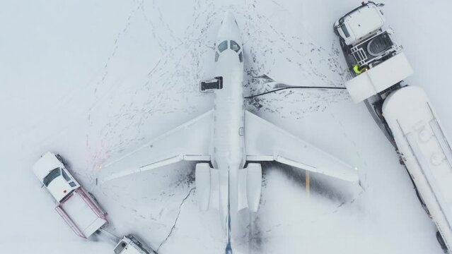 Refueling of private business jet airplane with snow covered tarmac, aerial
