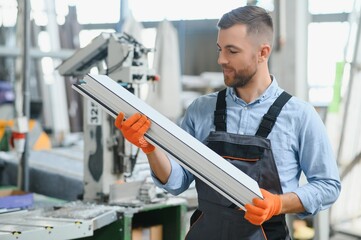 Fototapeta premium Factory for aluminum and PVC windows and doors production. Manual worker assembling PVC windows and doors
