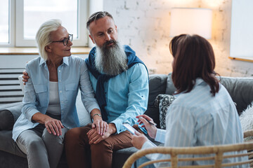 Senior couple, mature man and woman, husband and wife sitting on the sofa on the therapy session at...
