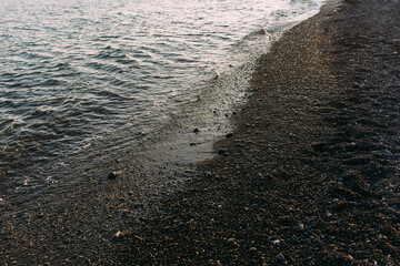  Seashore with pebbles and stones in the evening at sunset