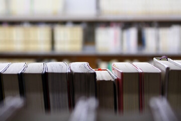 View of books on a shelf in a library with a blurred foreground and background.