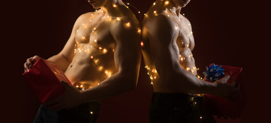 Sexy shirtless Santa. Sexy muscular men. Concept of the twins. Two twin brothers with bare naked body torso. Gay night club, banner for Christmas.