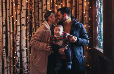 family with a baby in a cozy house in winter