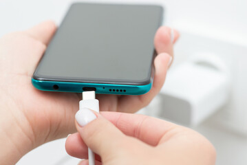 Inserting usb type-c into smartphone, close up. Modern fast charging of the device, universal usb...