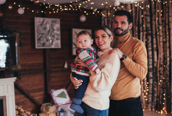 family with a baby in a cozy house in winter