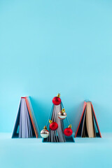 Book decorated like Christmas tree. Creative minimal concept.
