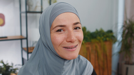 Portrait of happy calm young muslim business woman wearing hijab headscarf smiling friendly, glad...
