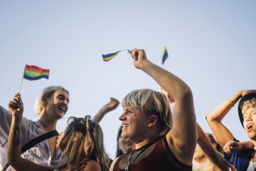 Happy non-binary person with friends enjoying in LGBTQIA rights parade