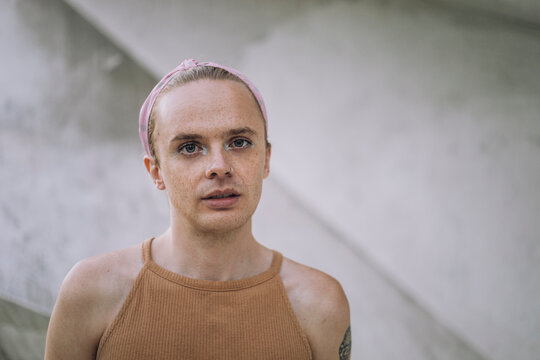 Portrait of non-binary person against wall