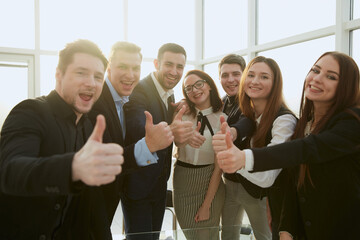 team of young professionals giving a thumbs up.