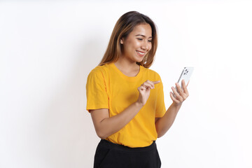 Hot asian pretty young woman smiling isolated on white, yellow t-shirt, using cellphone