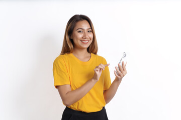 Hot asian pretty young woman smiling isolated on white, yellow t-shirt, using cellphone