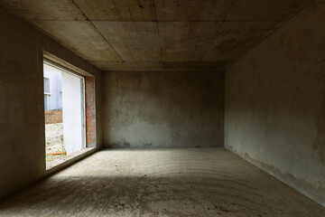 An empty concrete room in a newly built cottage.