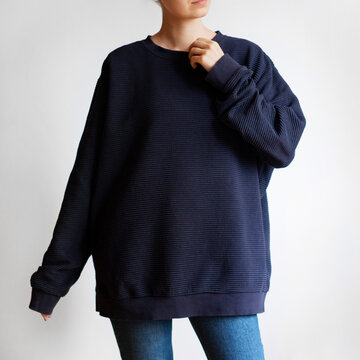 Woman Wearing Oversized Navy Sweatshirt And Blue Jeans Isolated On White Background