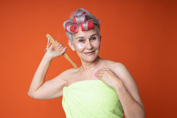 cheerful elderly woman in towel with washing brush