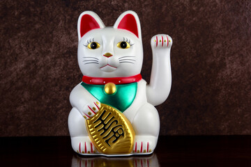 White Maneki Neko Beckoning Lucky Cat on a Polished Wooden Surface