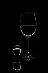 Glass goblet and bowl on black background