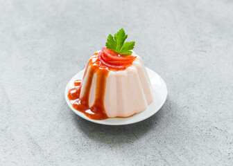 Cherry Tomato cream pudding, Panna Cotta with sauce, on a plate. Light gray background