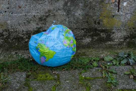 Erde in Not - Eingedr&uuml;ckter Beach Ball mit Globus-Design als Symbol f&uuml;r mangelnden Klima- und Umweltschutz.