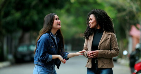 Diverse friendship, two women talking outside at park