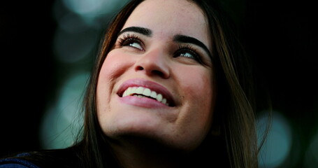 Contemplative young woman closing eyes and opening looking at sky smiling