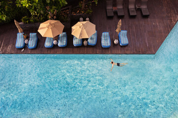 luxury hotel for summer holidays, man swimming in the pool, top view with copyspace