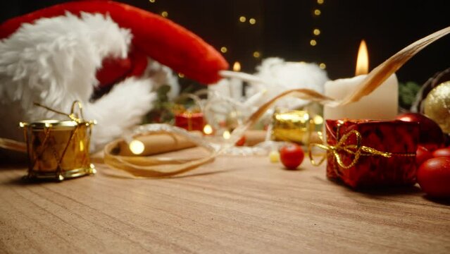 the image is out of focus. Decorations and Santa hat on the Christmas table, lanterns and candles with gifts.