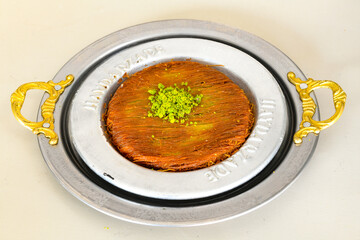 Pistachio kadayif on a plate. Turkish Dessert Kadayif with pistachio powder. Kunefe. Local name burma kadayif