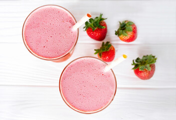 Strawberry yogurt fruit juice smoothie pink colorful fruit juice milkshake blend beverage healthy high protein the taste yummy In glass drink episode morning on white wood background.
