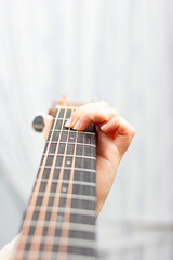 Woman's hand playing an acoustic guitar.