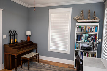 Home music room for students with a wood piano and blue gray walls