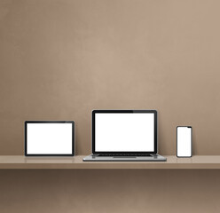 Laptop, mobile phone and digital tablet pc on brown wall shelf. Square background