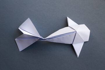 White paper fish origami isolated on a grey background