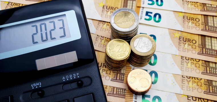 Energy And Financial Crisis In Europe In 2023. The Ever-increasing Cost Of Energy, Food And Goods. Calculator And A Lot Of Euro Coins On The Background Of Banknotes Of 50 Euros