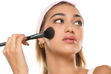 Woman using make-up brush, isolated on white background