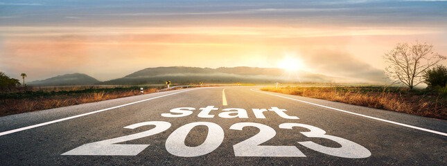 Start 2023 written on highway road in the middle of empty asphalt road of asphalt road at...