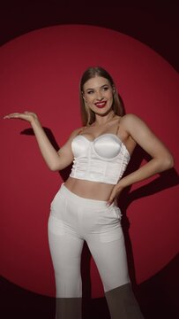 A model in a white bodysuit with an open neckline and bright make-up