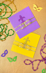 Multi color Mardi Gras background with beads and envelop. Top view