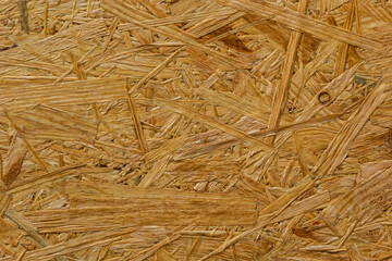 OSB board texture. Brown wooden background. Simple pressed chipboard pattern. Brown wood texture. Chip board background
