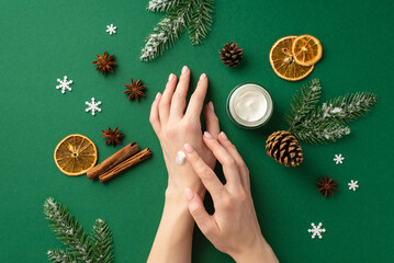 First person top view photo of young woman using hand cream from small jar pine cones dried orange...