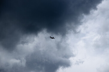 the sky with clouds and the silhouette of the plane in the sky, the background is natural