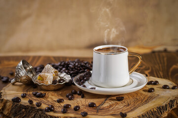 Hot Turkish coffee on wooden floor, Turkish delight next to it. 