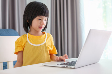 little asian girl student study online using laptop computer at home