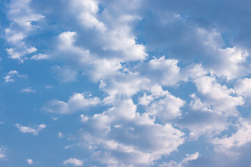 Fototapeta premium Clouds in the blue sky. Natural sky background texture, beautiful color. Peaceful blue sky with light clouds. The free form beauty of clouds and sky is perfect for background, backdrop and wallpaper.