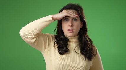 Portrait of happy smiling young woman 20s smiling and look around for friend find meet greet someone posing isolated on green screen background.