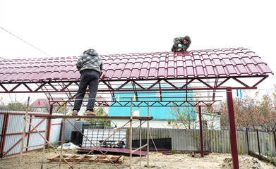 Naklejka premium Workers cover the canopy with metal sheets.